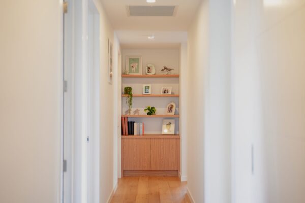 Hallway with custom built storage and shelving, demonstrating bespoke joinery and thoughtful residential interior design.