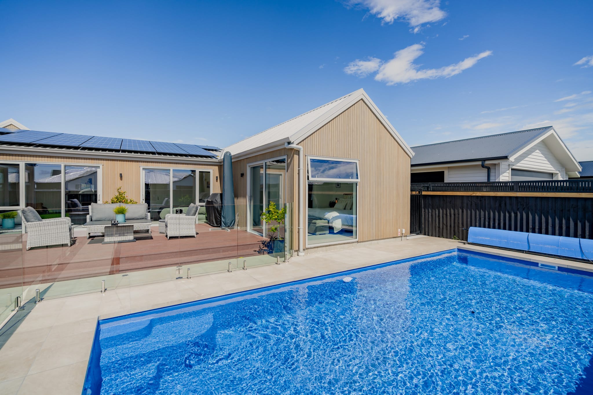 Outdoor pool and deck area of a contemporary new build home, highlighting quality residential construction, exterior detailing, and modern architectural design.