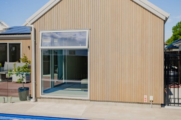 Side elevation of a modern new build home with vertical timber cladding, showcasing exterior construction detailing and architectural home design.