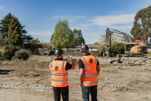 Two construction professionals on site discussing ground works, showcasing construction management, site planning, and early stage project development.
