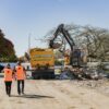 Two construction professionals walking through an active demolition and groundworks area, showcasing the early stages of building construction, project construction planning and the structured approach used in home construction and Commercial Construction projects.