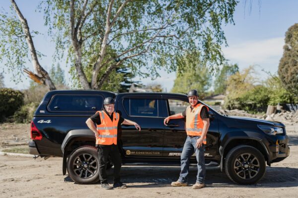 Two BP Construction team members standing beside a branded ute at a residential development site, highlighting the professionalism behind homebuilder operations, Design and build projects, bespoke renovations and housing development management.