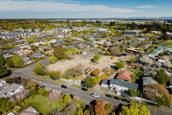 Aerial view of a residential area featuring an active construction zone for new build developments and architecturally designed homes, demonstrating homebuilding company capability, construction NZ planning, building reports and future modern house construction.