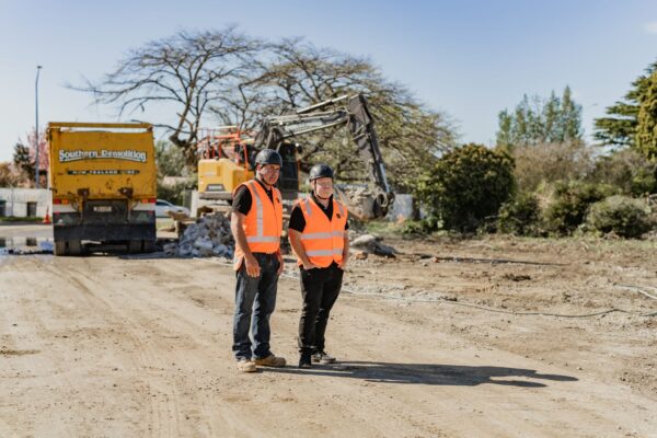 Two construction NZ workers on a demolition and refurbishment site, part of project construction for new builds, aged care construction, commercial refurbishment, and future architecturally designed homes within a new housing development.