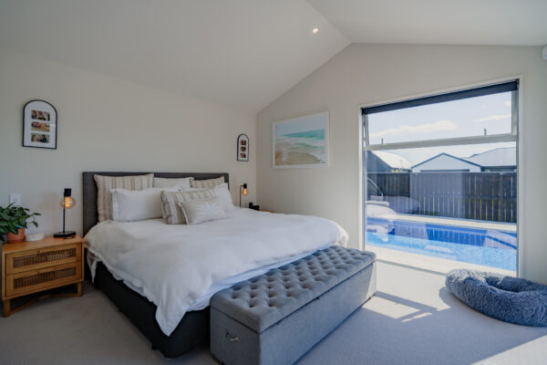 Master bedroom in a modern new build house overlooking outdoor living, showcasing bespoke design and build, quality home construction, and architectural home detailing.