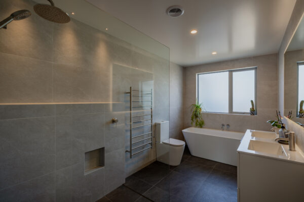 Contemporary bathroom with walk in shower and bath, part of a bespoke new build home showcasing quality renovations, building construction, and design and build services.