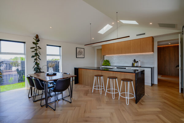 Open plan kitchen and dining area in a modern house, featuring architectural plans brought to life by a homebuilding company specialising in new build homes and construction projects.