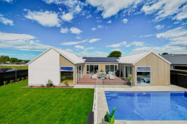 Aerial view of a bespoke new build home with pool and outdoor living, highlighting architecturally designed homes, home builder expertise, and full construction and management services.