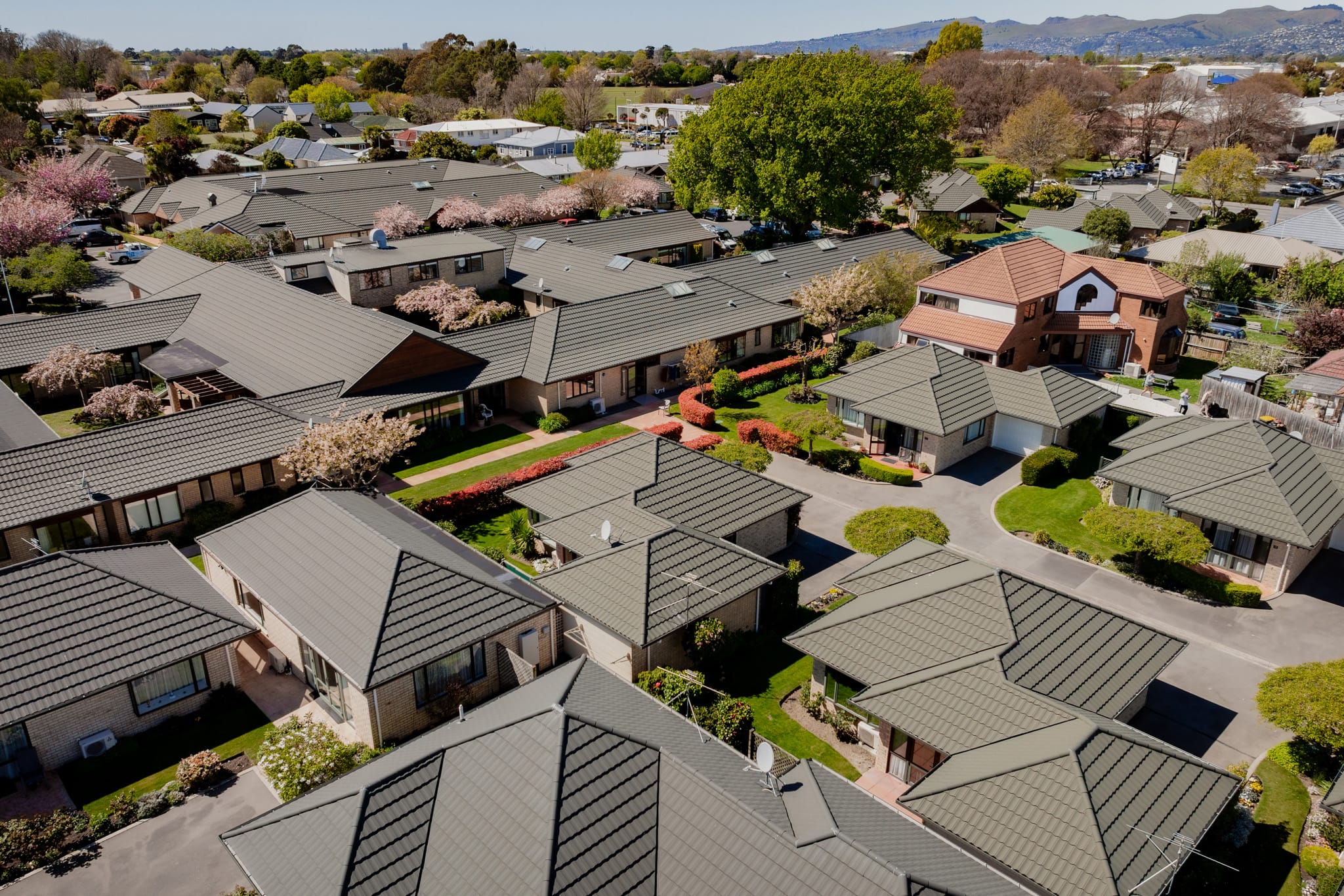 A broader aerial perspective of modern houses, architecturally designed homes and new build houses within an organised community, built through coordinated construction and management, project construction processes and Commercial Construction capability supporting long-term residential and aged care developments.