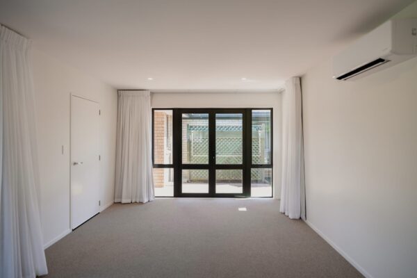 A refurbished living space with wide doors leading outdoors, showing a clean architectural build typical of new build developments, commercial refurbishment needs within aged care settings and construction NZ professionals who manage construction projects from Design and build through to completion.