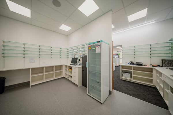 A dispensary work area completed during a pharmacy commercial fit out, featuring new shelving, cabinetry and workstations, showcasing Commercial Construction, bespoke refurbishment and construction and management capability.