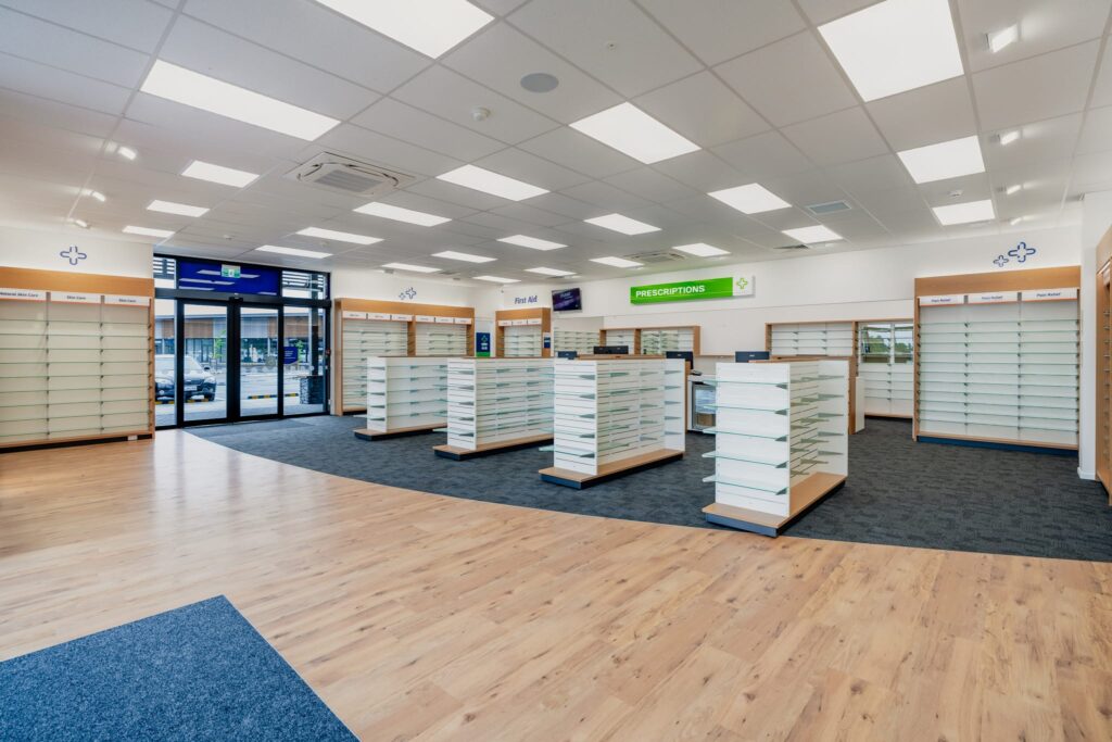 A completed retail pharmacy interior featuring new shelving and commercial fit out works, highlighting Commercial Construction expertise, construction and management capability, and refurbishment standards suitable for a property inspection report.