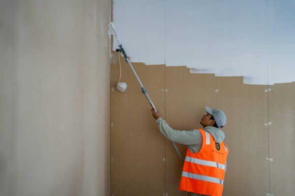 A tradesperson painting interior walls during a commercial refurbishment project, demonstrating bespoke renovations, Commercial Construction skill, building construction tasks and construction and management expertise.