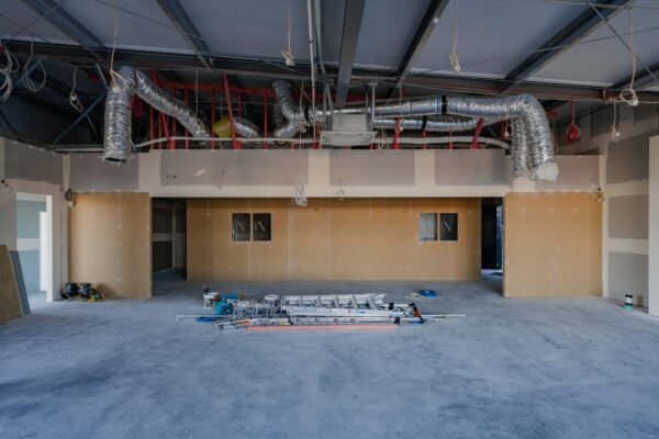 An interior construction zone with exposed HVAC ducting and ceiling services during a commercial fit out, highlighting Commercial Construction, project construction progress, building construction systems and construction NZ technical capability.